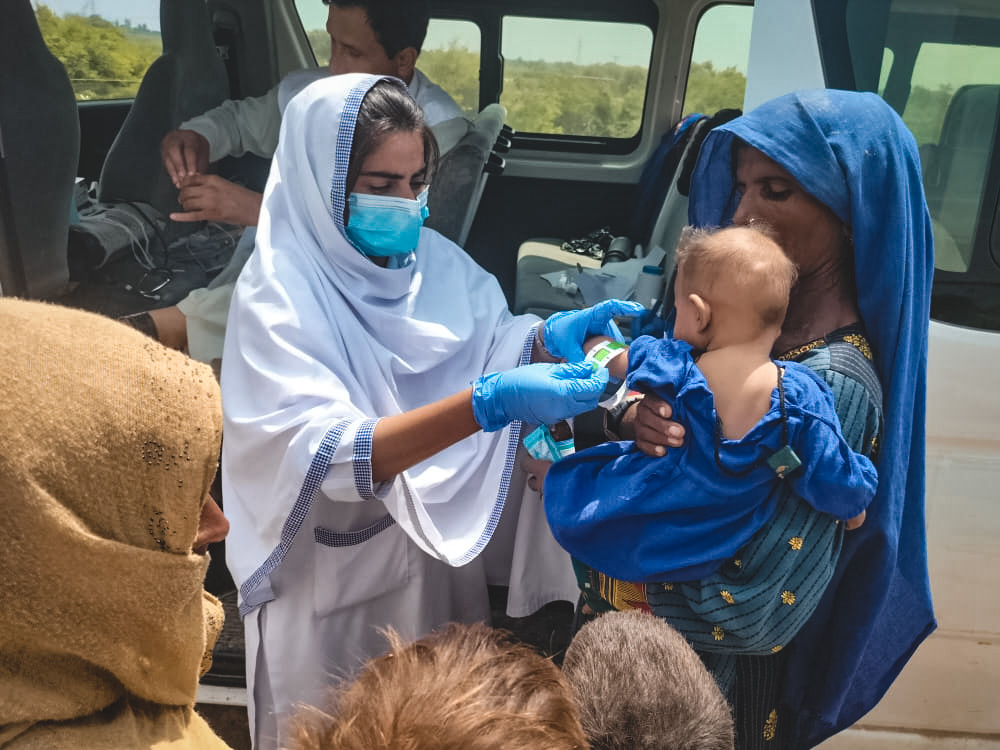 Notre collègue Akeela évalue les signes de malnutrition chez un enfant. La province du Sindh, qui produit environ la moitié de la nourriture de tout le Pakistan, a vu environ 90 % de sa récolte perdue dans les inondations. Des centaines de milliers de maisons ont aussi été emportées, laissant la population à la rue ou dans des camps, exposés au risque de malnutrition. Comme de nombreux membres de nos équipes, Akeela a elle-même perdu sa maison dans les inondations. © MSF, 6 septembre 2022.