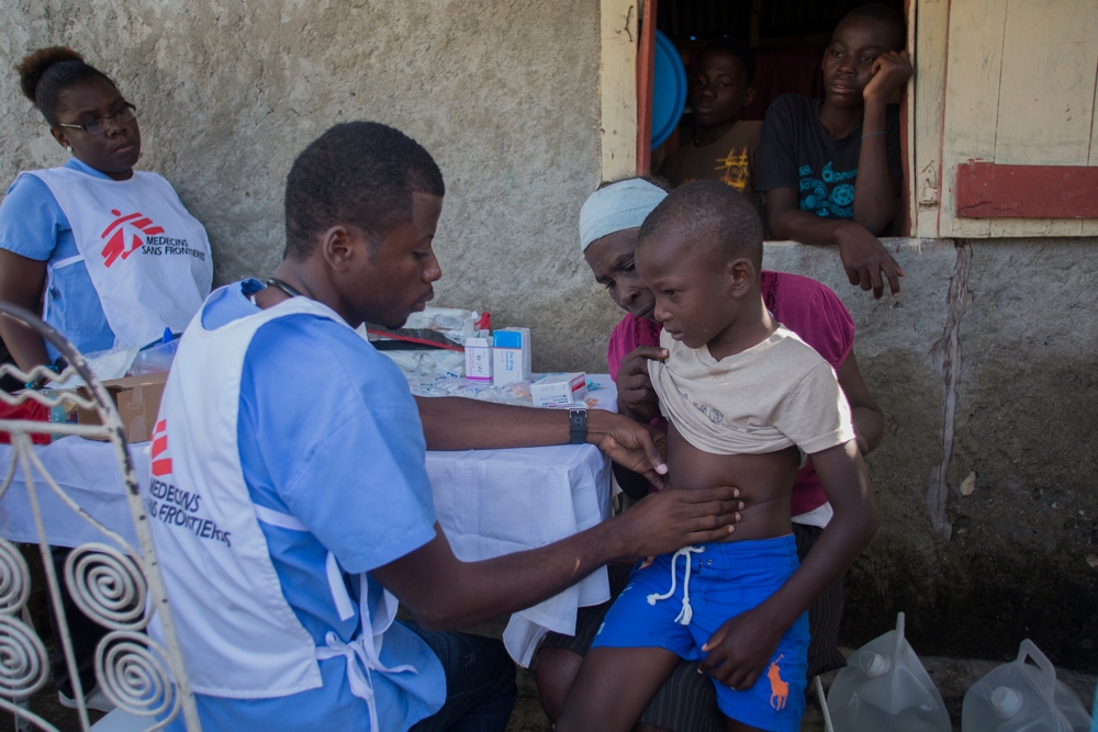 Medgy, médecin MSF, examine un enfant de cinq ans accompagné par sa grand-mère à Coteaux 